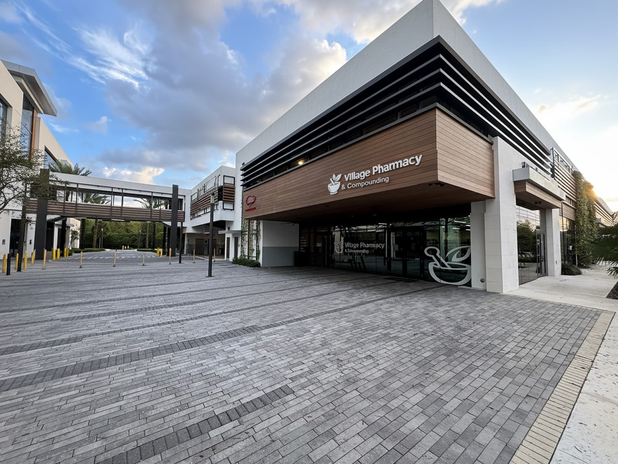 La fachada de madera de Village Pharmacy & Compounding al atardecer